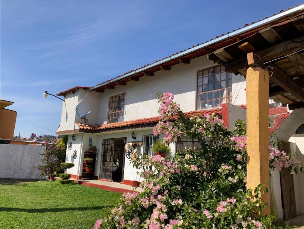 une maison avec des fleurs roses devant elle dans l'établissement Villa Sofia, à Tlatlauquitepec