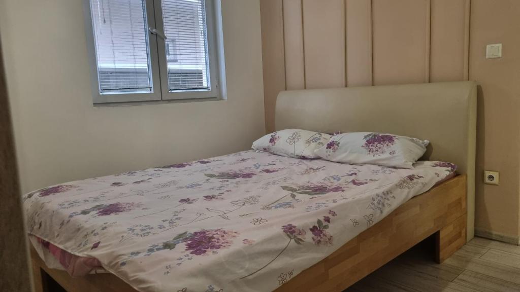 łóżko z kwiatową narzutą i 2 poduszkami w obiekcie Apartman San w mieście Brczko