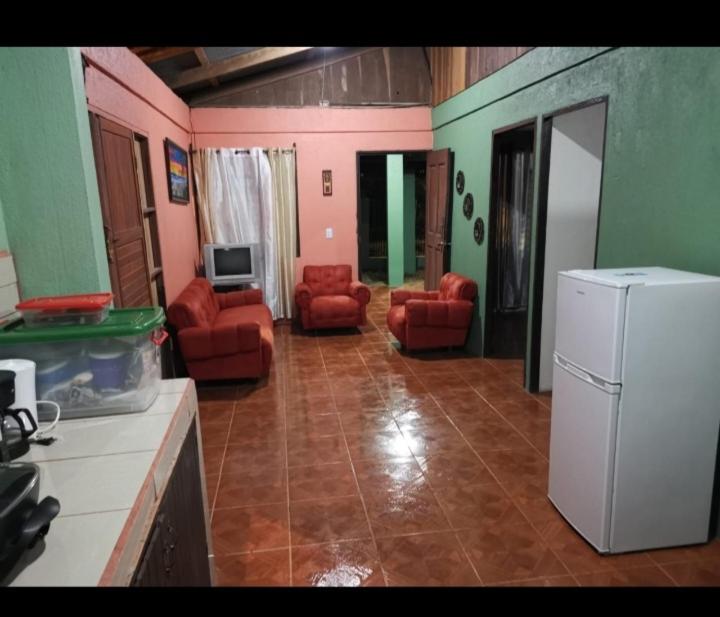 uma sala de estar com cadeiras vermelhas e um frigorífico branco em Casa Santa Cruz em Santa Cruz