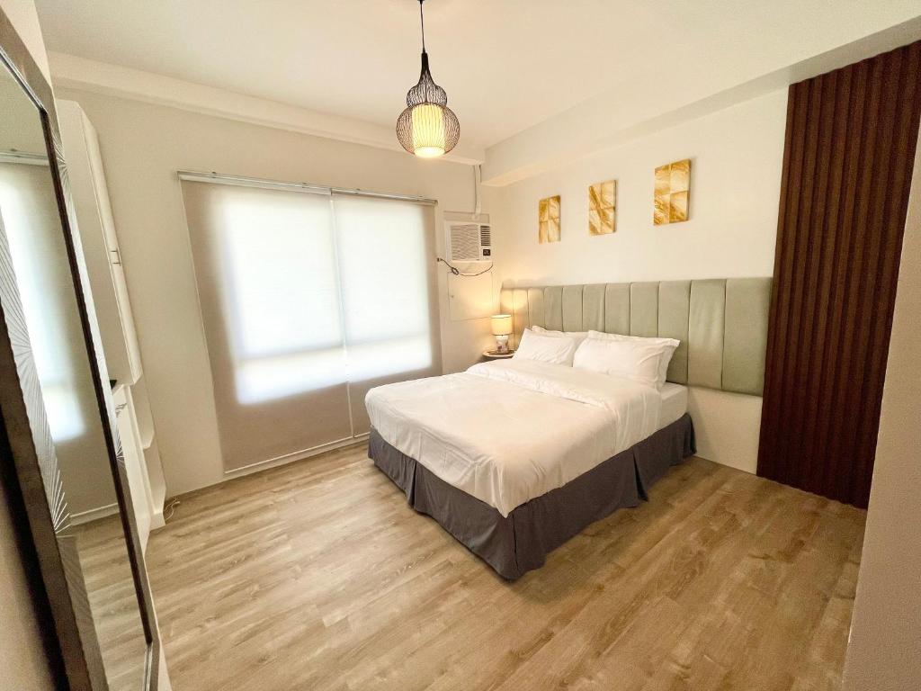 een slaapkamer met een bed en een groot raam bij One bedroom Condo Suite in Bacolod City in Bacolod