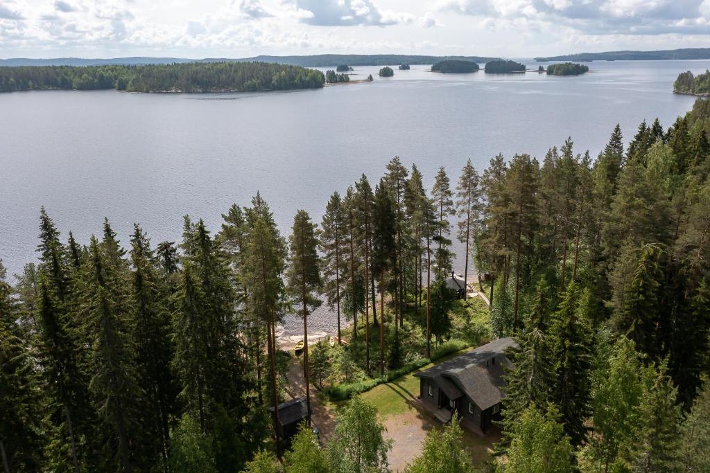 an aerial view of a house on the shore of a lake at Kujanpää | Paajoen Vuokramökit in Himos