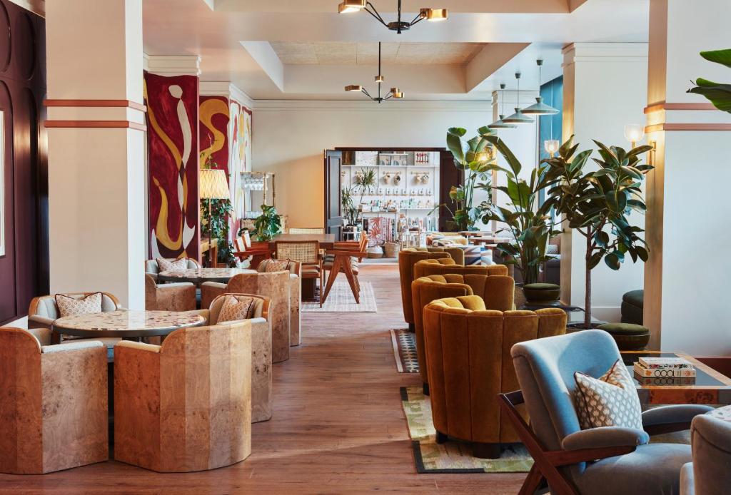 a lobby with couches and tables and chairs at The Hoxton, Shepherds Bush in London