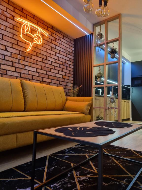 a living room with a couch and a brick wall at Apartament Loft KB-Ściegiennego (garaż, centrum) in Kielce