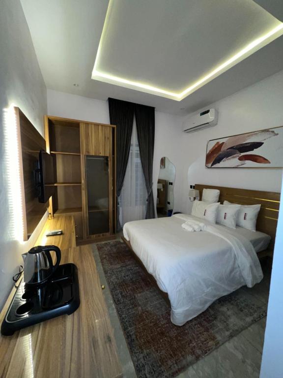 a bedroom with a large white bed and a television at Bricks Residence in Lekki