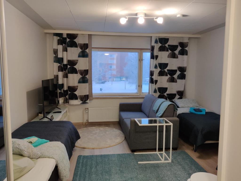mały salon z kanapą i oknem w obiekcie M Apartments Rahola w mieście Tampere
