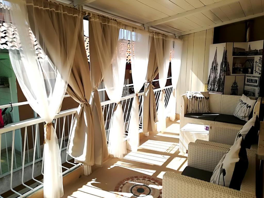 a room with curtains and chairs and a window at The 727 Sottomarina in Sottomarina