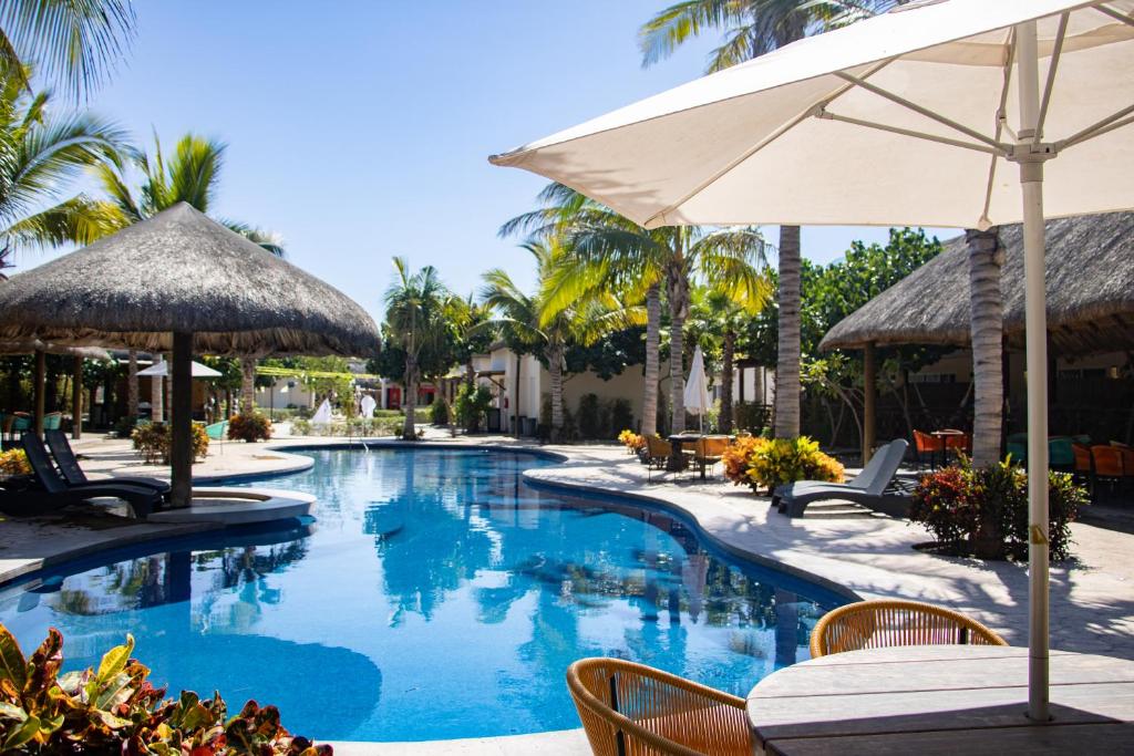 a swimming pool with a table and an umbrella at Casa en nuevo Altata, Punta Esmeralda Grand in Altata