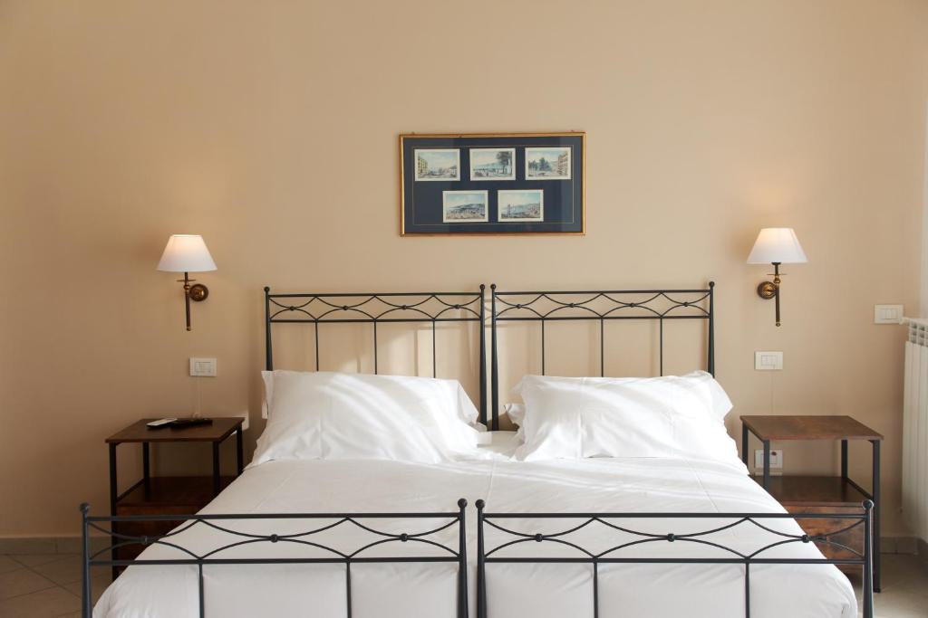 a bedroom with a bed with white sheets and pillows at Villa Margherita in Naples