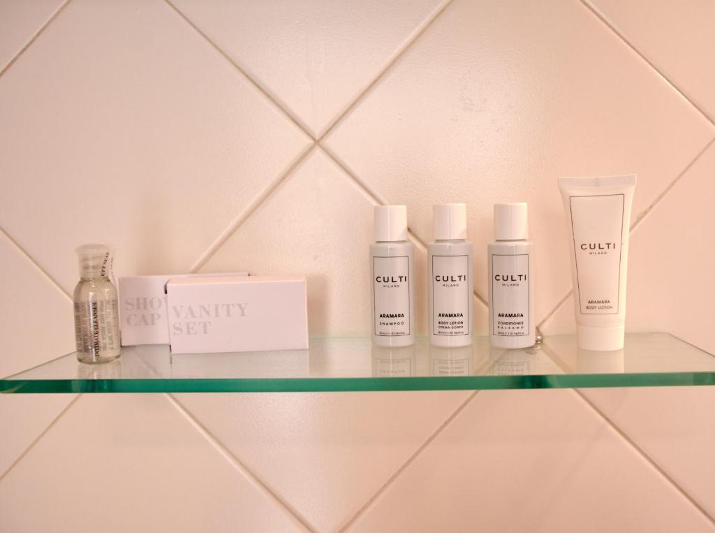 a shelf with four bottles of moisturizers on it at Villa Margherita in Naples