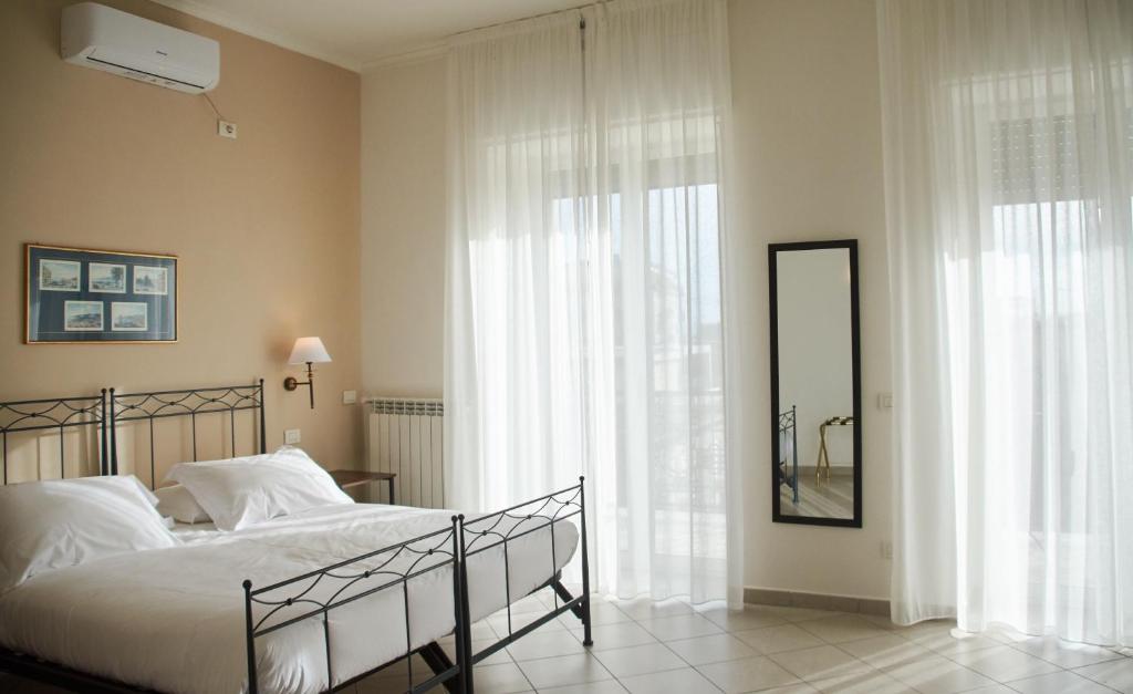 a bedroom with a bed and a large window at Villa Margherita in Naples