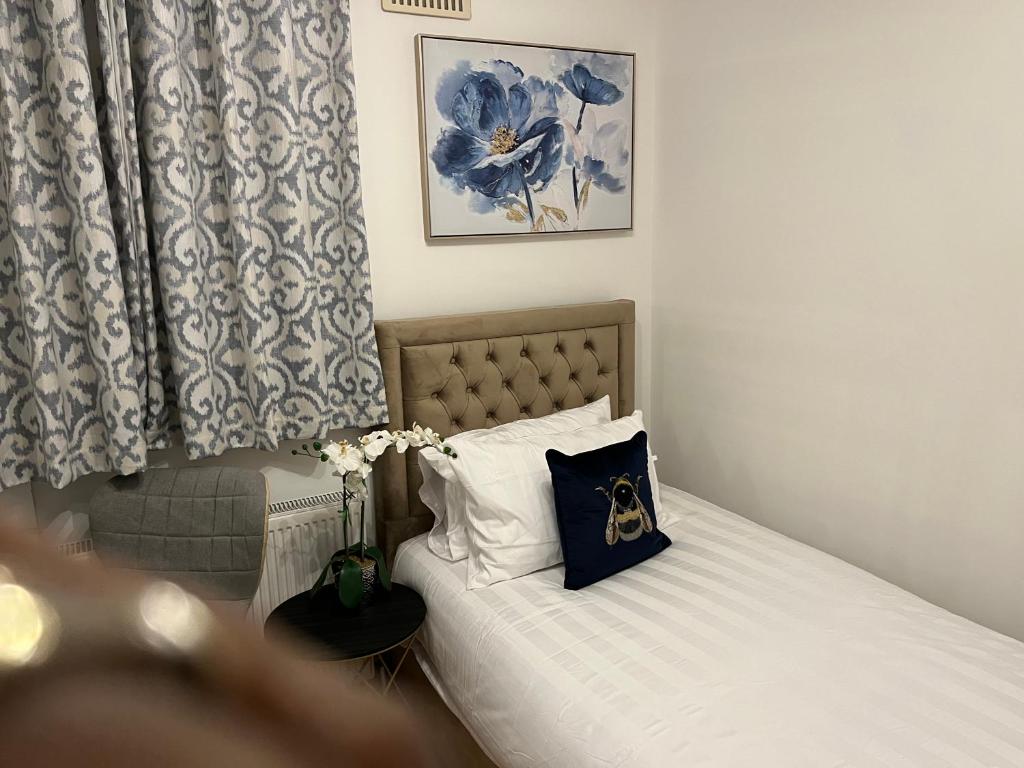1 dormitorio con cama con almohada en TJ Homes - Double room with Single Bed - 3 Min to Tube station - London en Ruislip