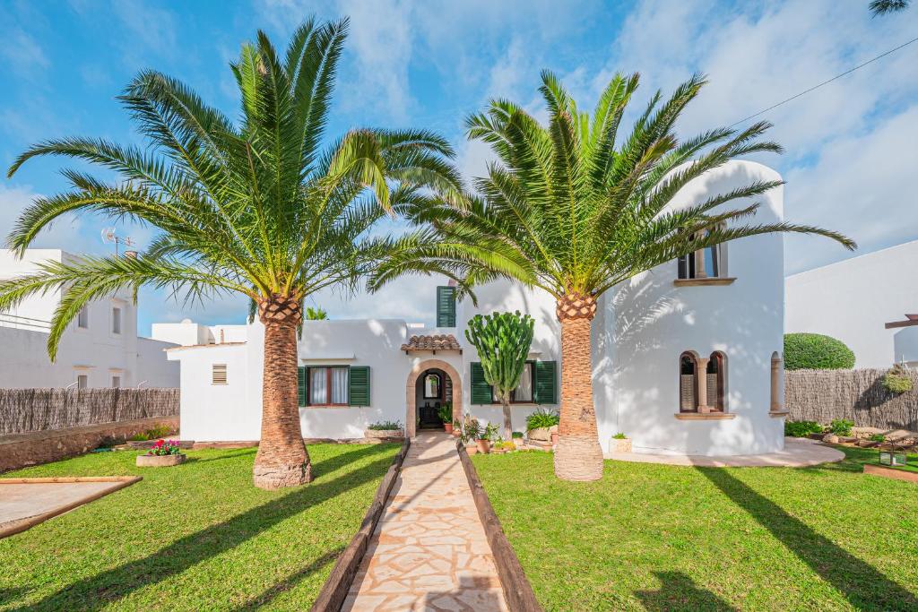 a house with two palm trees in front of it at Casa Carmela in Cacla D'or