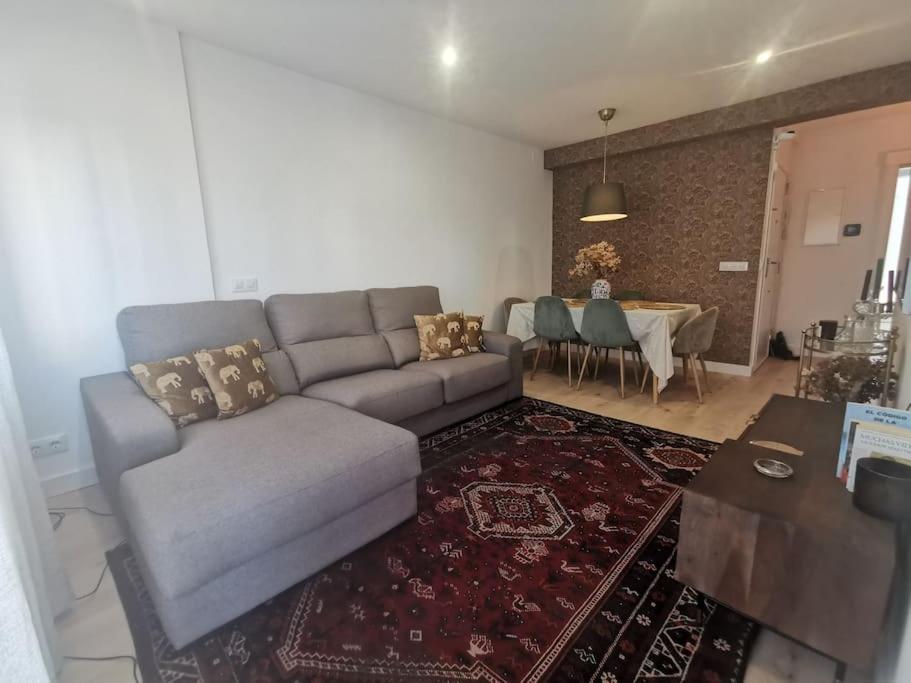 ein Wohnzimmer mit einem Sofa und einem Tisch in der Unterkunft Tomás Paredes, Vigo, 3 habitaciones in Vigo