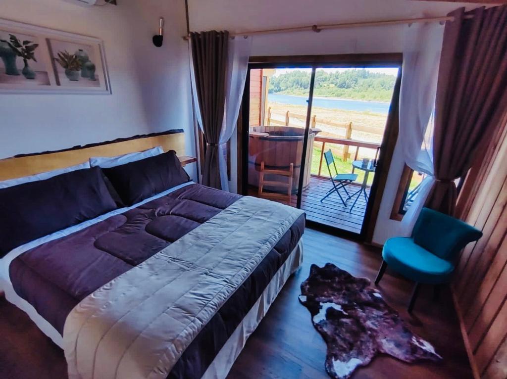- une chambre avec un lit et une vue sur l'océan dans l'établissement El Encanto de Antilhue, à Valdivia