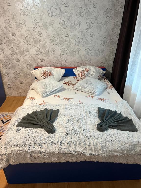 a bed with two pairs of gloves sitting on it at Comfy Condo Zalau in Zalău