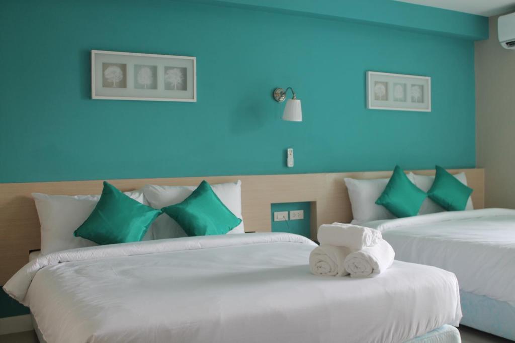 Duas camas num quarto com paredes azuis em V-Ocean Palace em Hat Yai