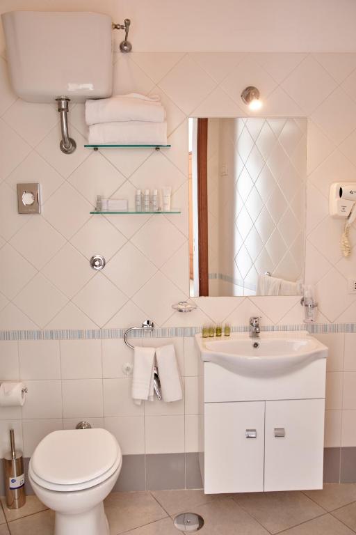 a bathroom with a toilet and a sink and a mirror at Villa Margherita in Naples