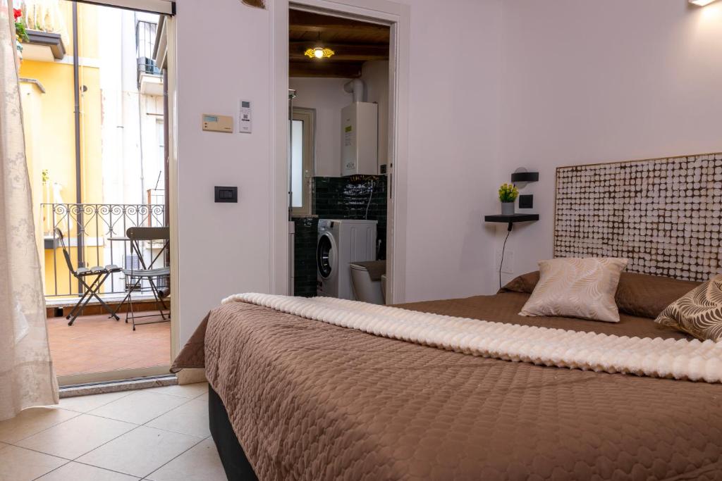 een slaapkamer met een groot bed en een balkon bij Amunì Taormina in Taormina