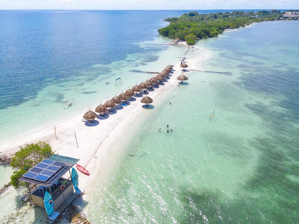 ein Strand mit Sonnenschirmen und Menschen im Wasser in der Unterkunft Hotel Isla Palma Reserva Natural in Isla Palma