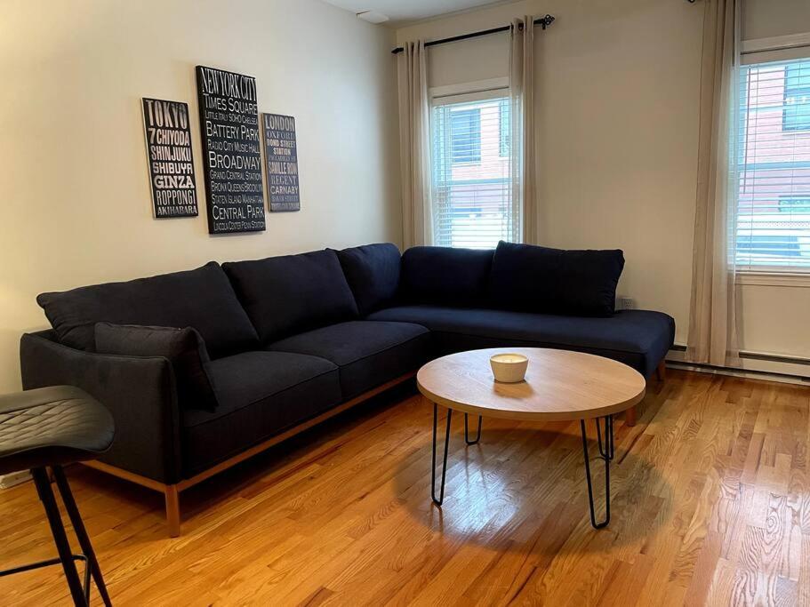 a living room with a blue couch and a table at Lovely Two Bedroom Condo in South Boston in Boston