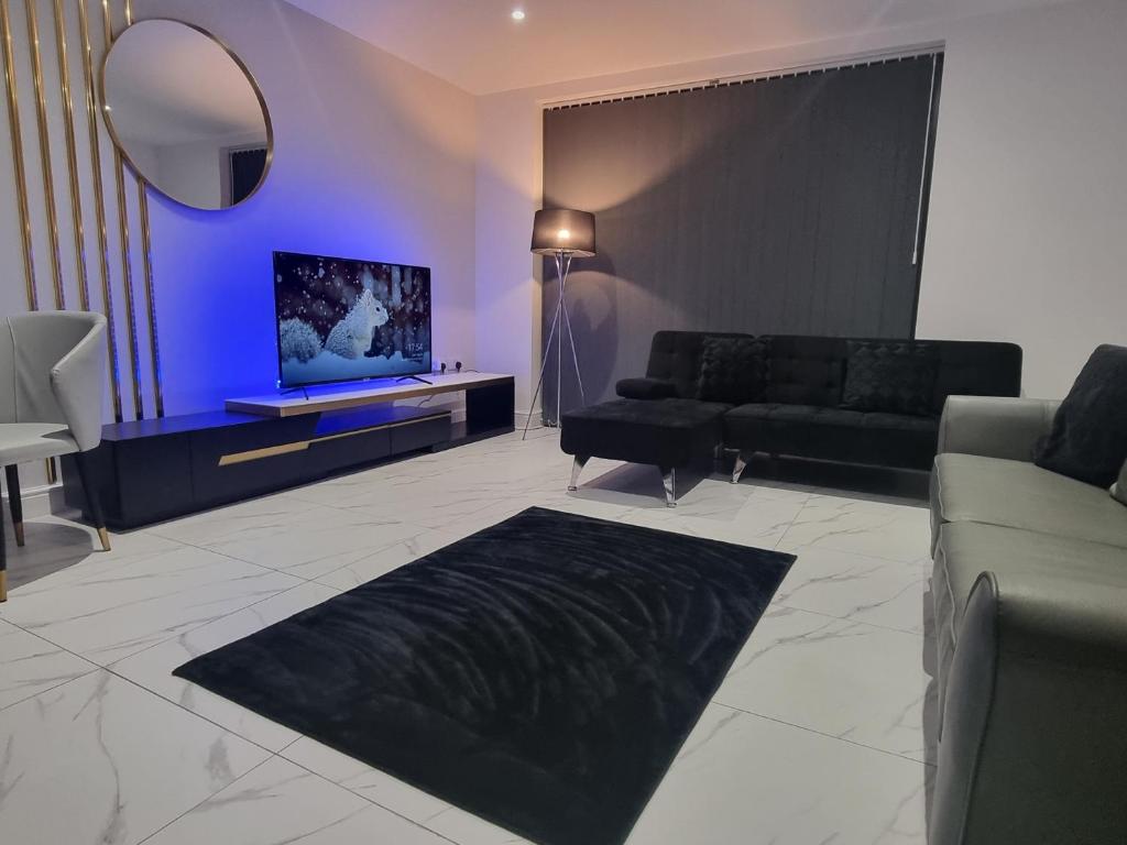 - un salon avec un canapé et une télévision dans l'établissement MNA Superior Apartments, à Bradford