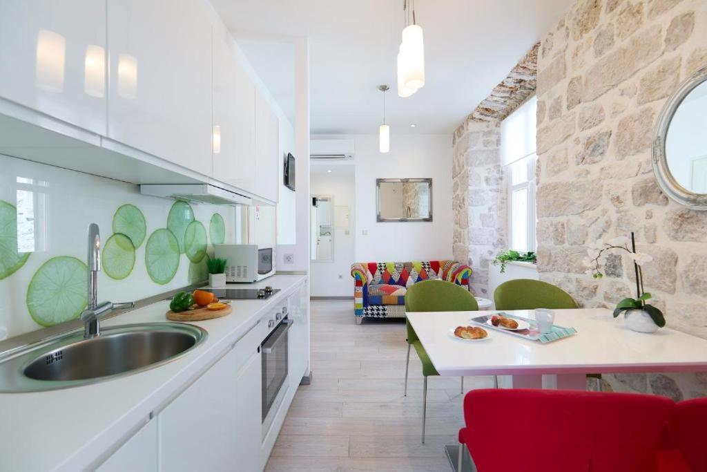 a kitchen with a sink and a living room at Festa Apartments in Dubrovnik