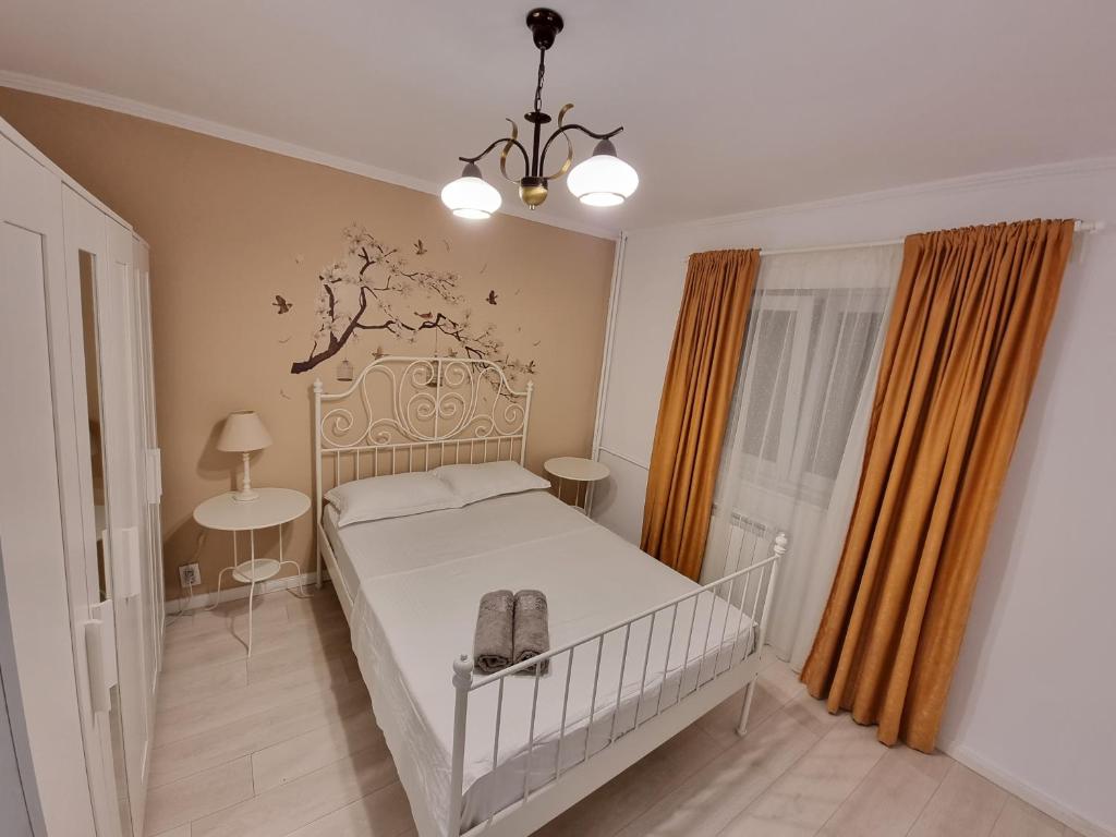 een slaapkamer met een wit bed en oranje gordijnen bij Aviatiei Apartments near Caramfil street in Boekarest