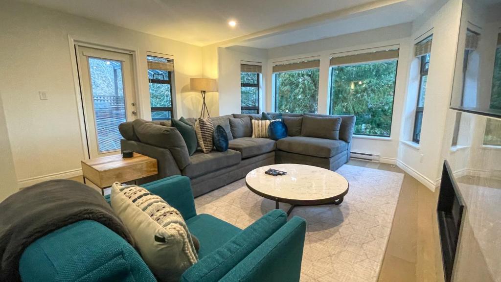 a living room with couches and a table at 3BR Stunning Recently Renovated Condo by Harmony Whistler in Whistler