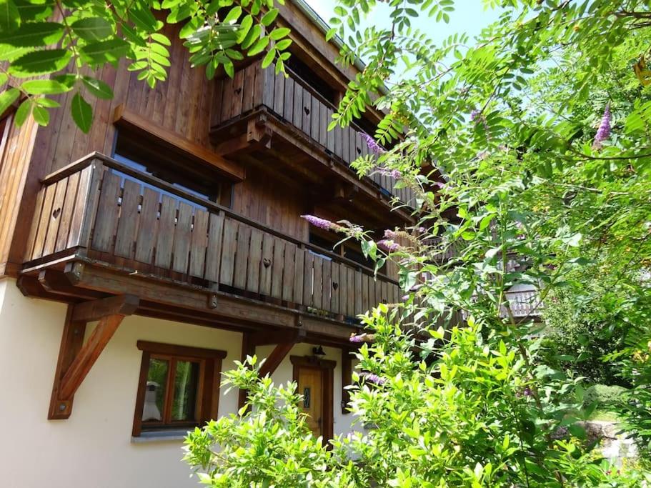 a wooden balcony on the side of a building with trees at Chalet Belle Folie in Saint-Jean-d'Aulps
