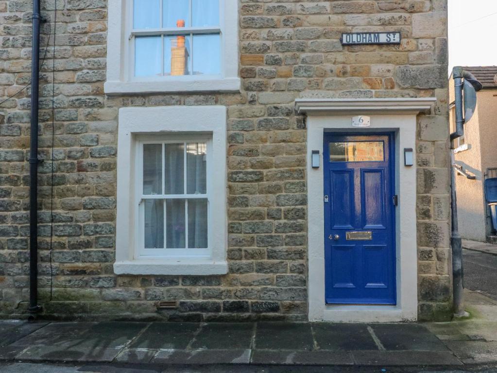 a brick building with a blue door and a window at The Bay Cottage in Morecambe