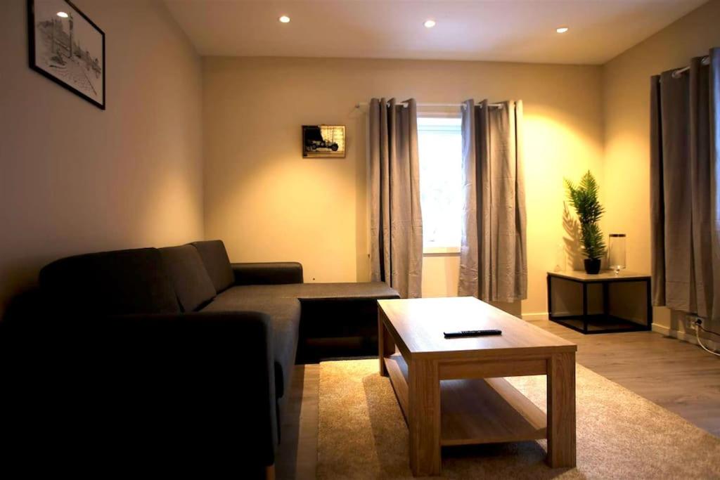 uma sala de estar com um sofá e uma mesa de centro em Sentral leilighet med 3 soverom em Harstad