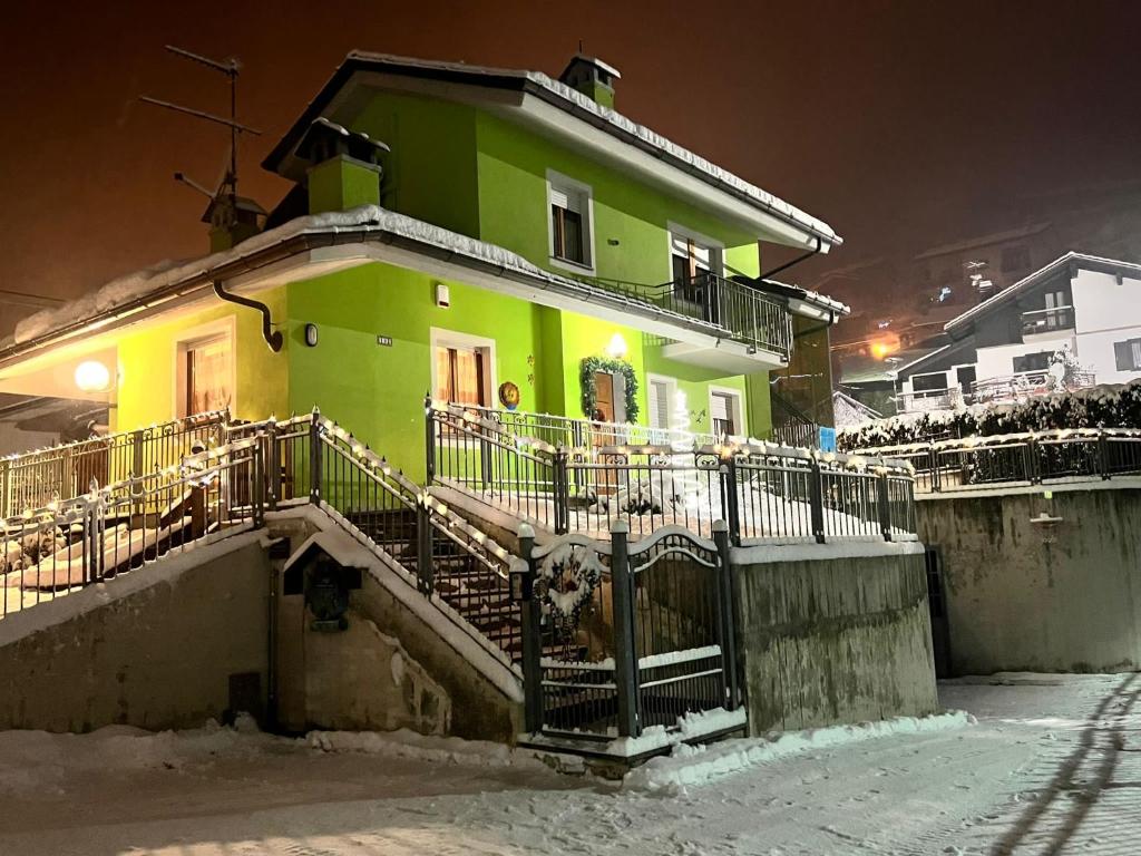 een groen huis met een hek ervoor bij Villa Serena in Aosta