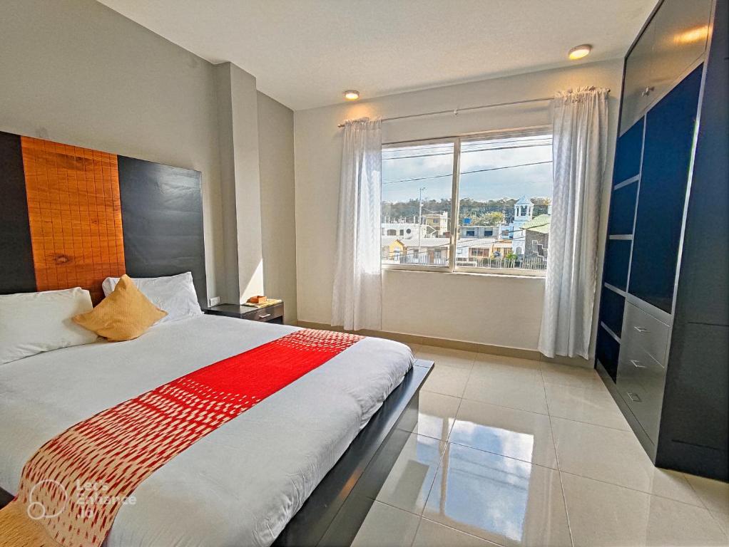 1 dormitorio con cama grande y ventana grande en Suite Familiar en Puerto Ayora, en Puerto Ayora