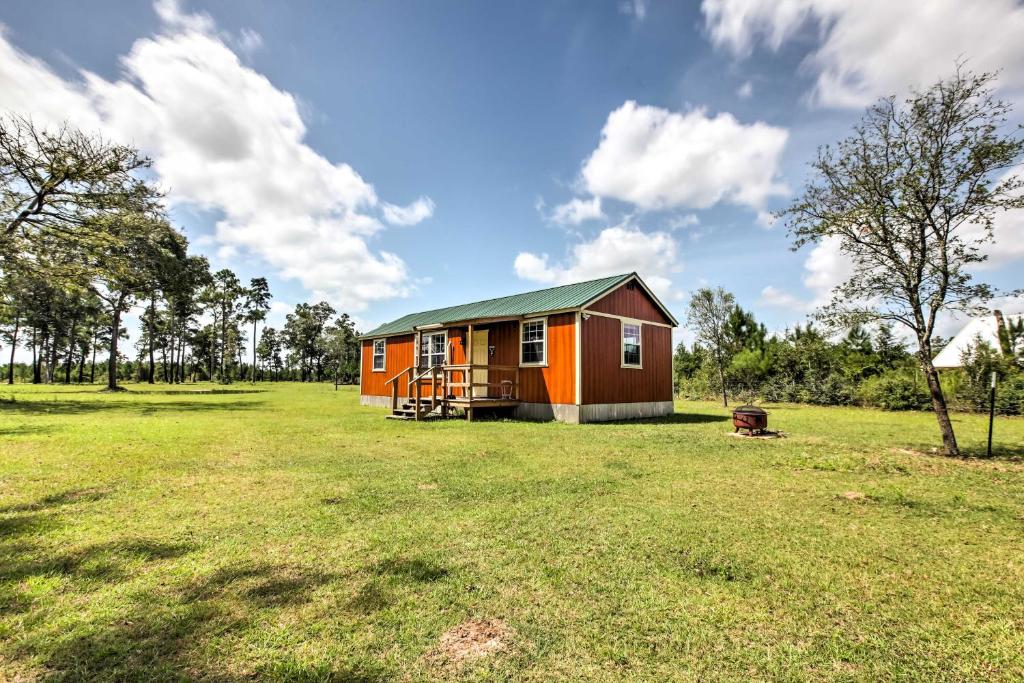a small house in the middle of a field at Tranquil Plantersville Cabin Farm Animals On-Site in Magnolia
