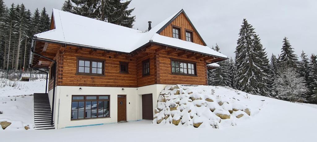 domek z bali w śniegu i śniegu w obiekcie Drevenica Lesanka w Demianowskiej Dolinie