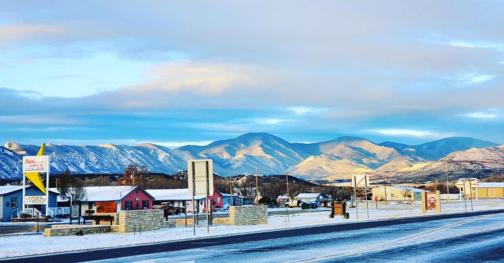 a small town with snow covered mountains in the background at Hikers Cimarron Inn & RV Park in Cimarron