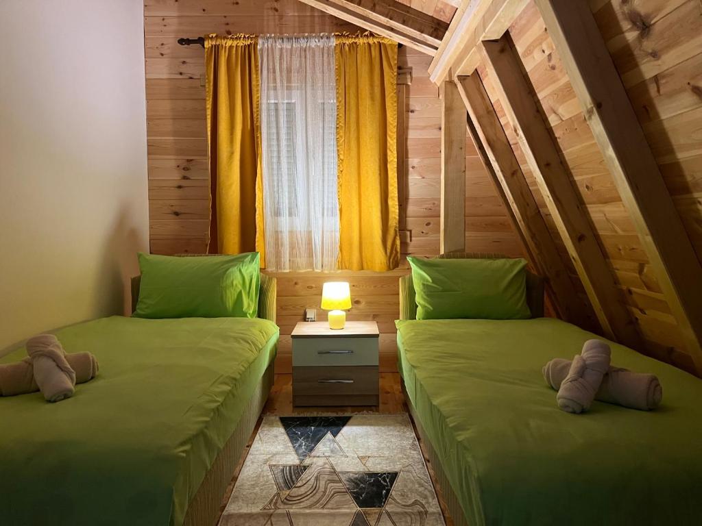 2 Einzelbetten in einem Zimmer mit Fenster in der Unterkunft LAF Guest House in Kolašin