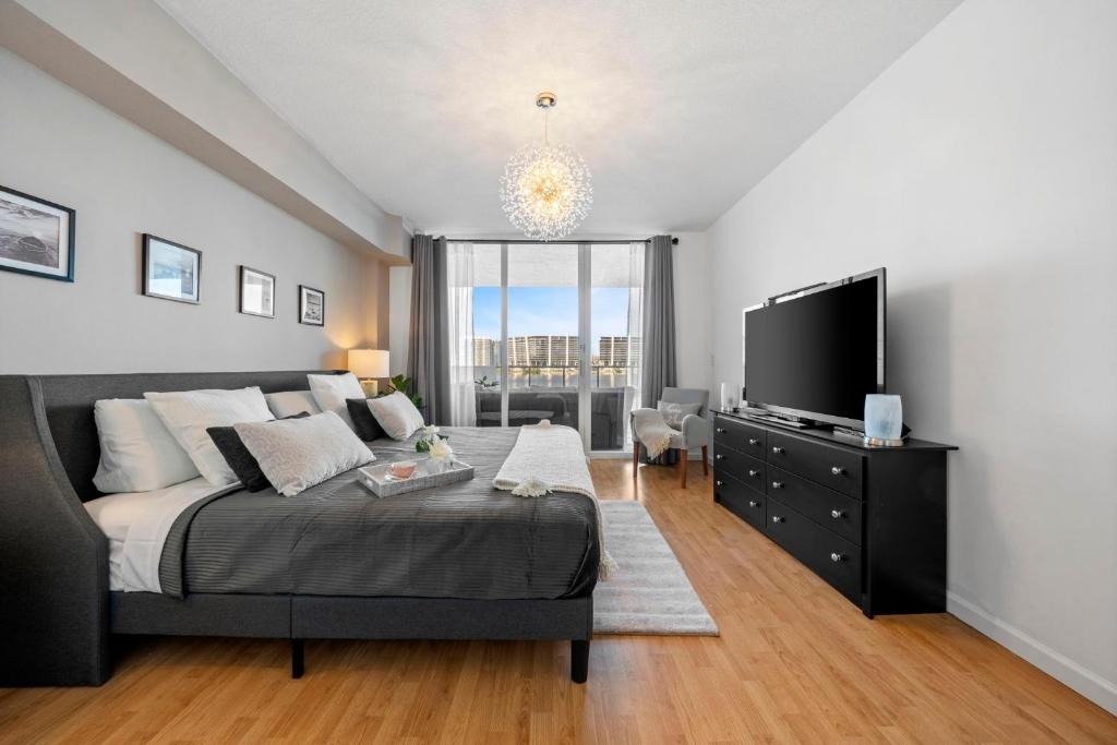 een slaapkamer met een groot bed en een flatscreen-tv bij Waterfront luxury new apartment in Miami Beach