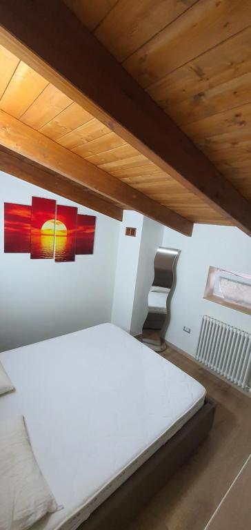 MarconiaにあるCasa Vacanze Luxury CASELLO 28の白いベッドと壁に絵画が飾られたベッドルーム1室