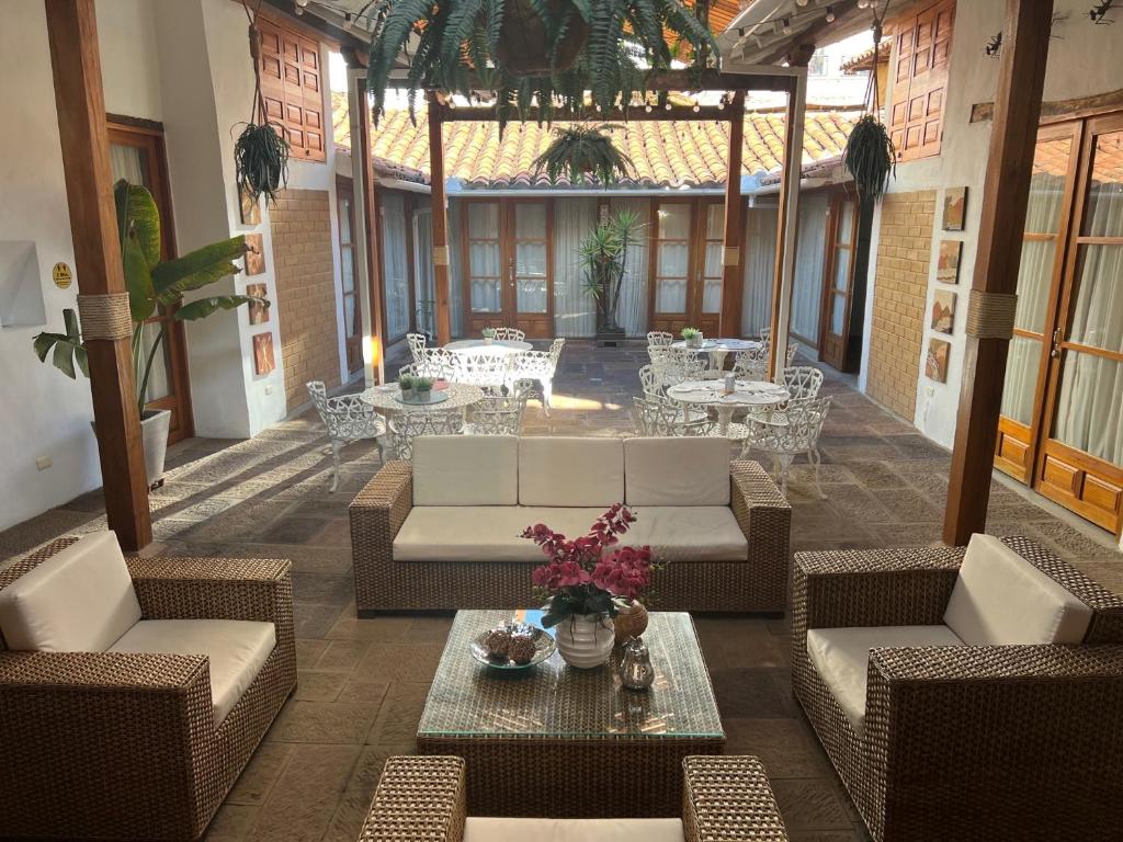 eine Außenterrasse mit Sofas, Tischen und Stühlen in der Unterkunft HOTEL BOUTIQUE EL CAMPANARIO in San Gil