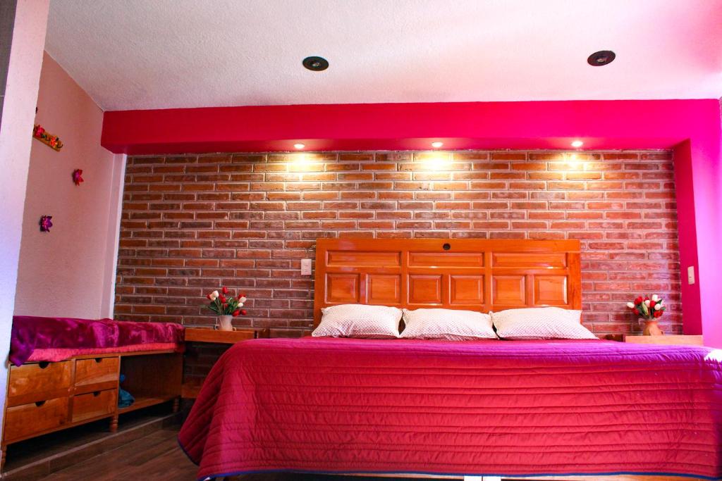 a bedroom with a large bed with a brick wall at Hospedaje Ensueño in Zacatlán