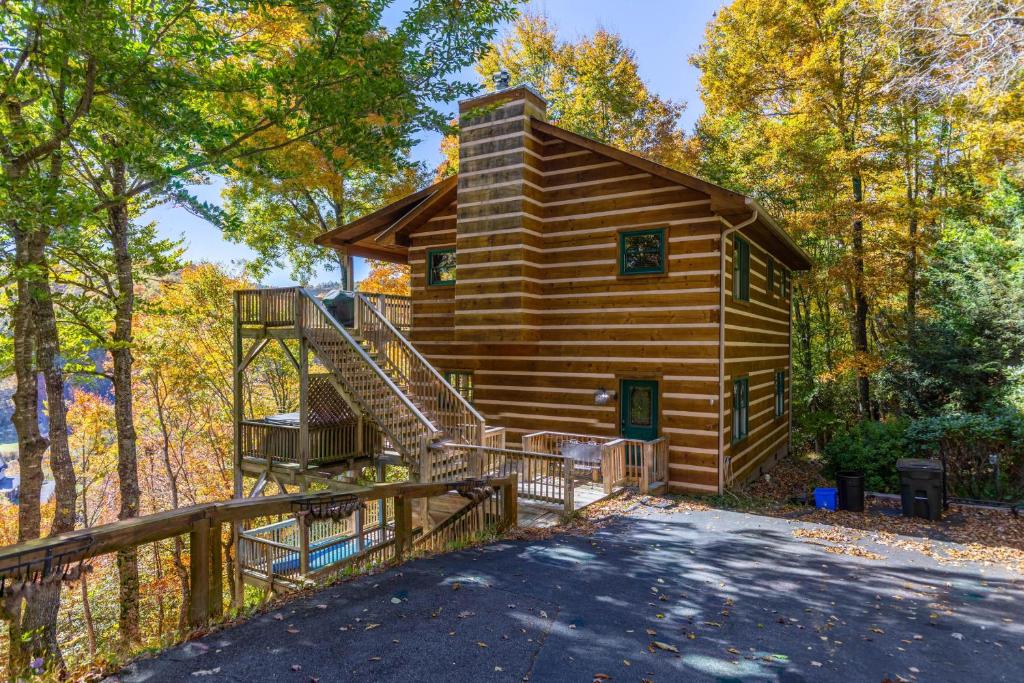 eine Blockhütte mit einer Treppe im Wald in der Unterkunft Log Inn at River Ridge in Boone