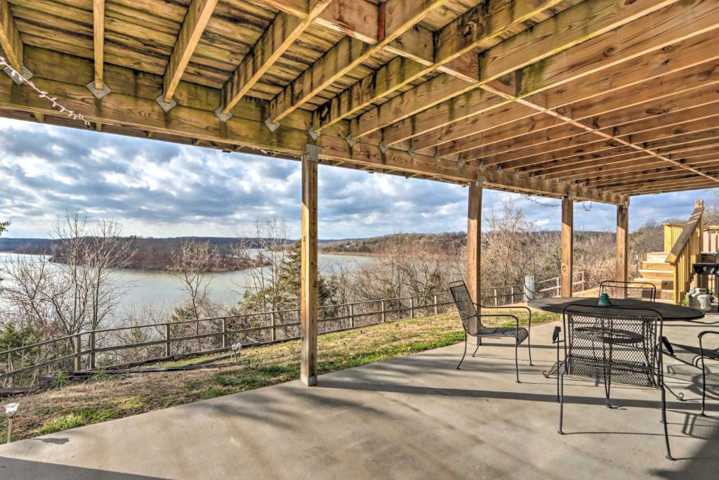 a patio with a table and chairs and a view of the water at Lakeside Home with Deck Near Hunting and Fishing in Galmey