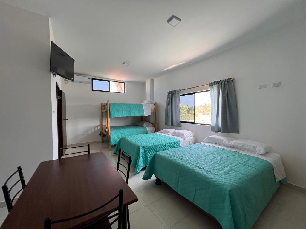 a room with two beds and a table and a dining room at La Veleta in Playas
