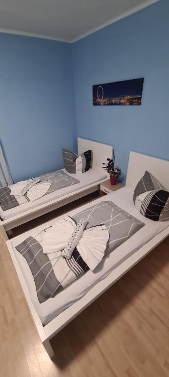 zwei Betten in einem Zimmer mit einer blauen Wand in der Unterkunft Möblierte 3-Zimmer-Wohnung im Herz von Schwandorf! in Schwandorf in Bayern
