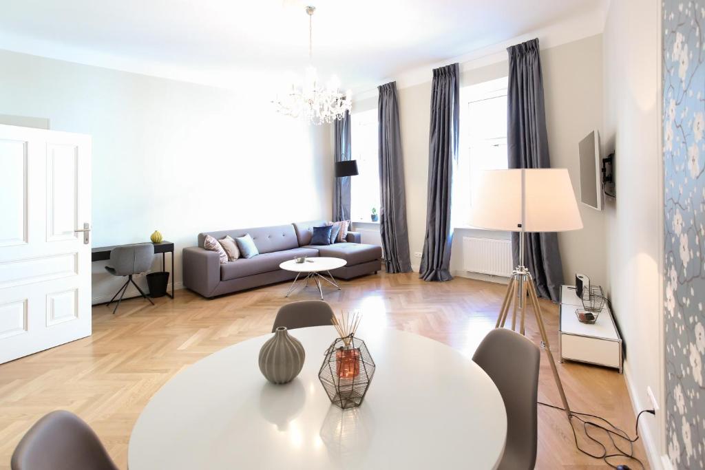 salon z białym stołem i kanapą w obiekcie Pink Grapefruit City Condo w Wiedniu