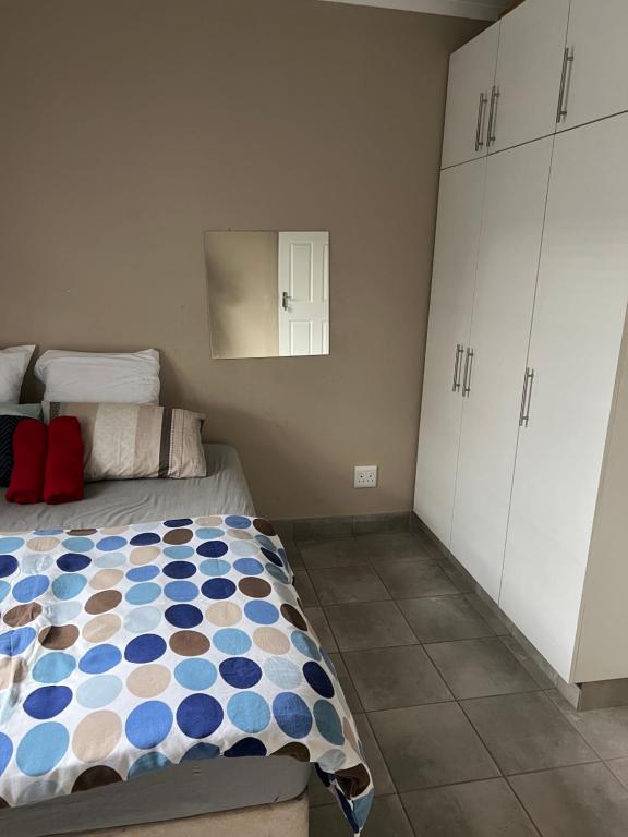 a bedroom with a bed and a white cabinet at Ikhaya guesthouse2 in Pietermaritzburg