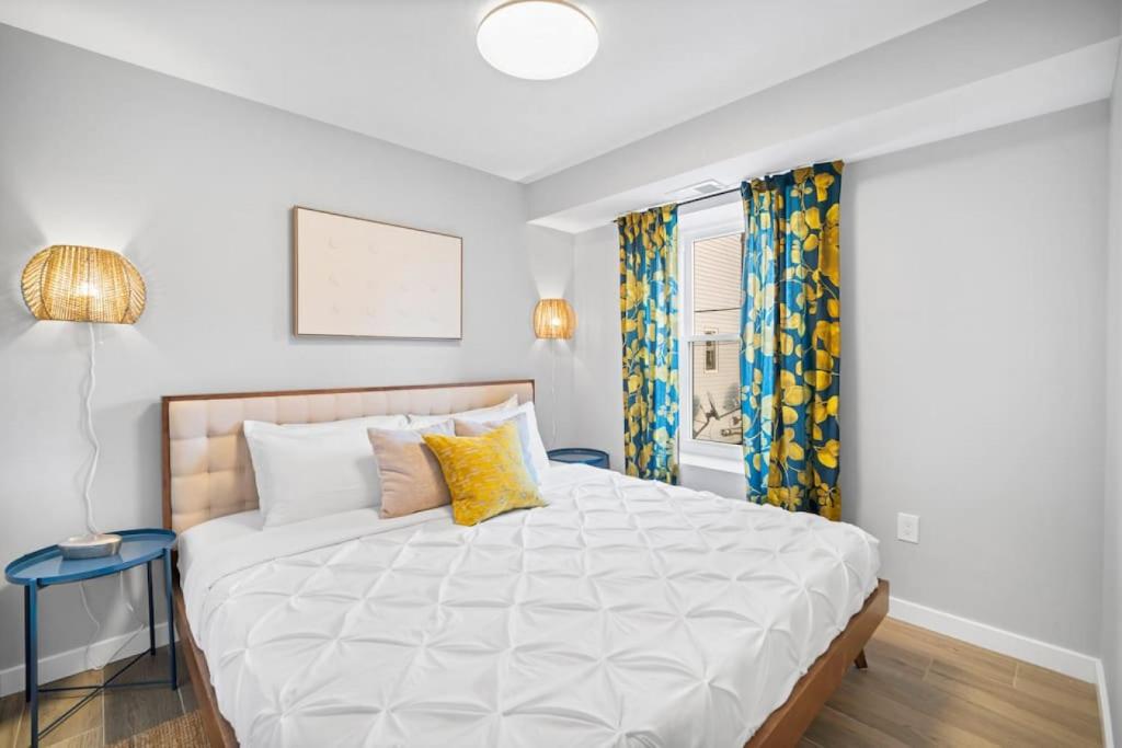 a bedroom with a large white bed with yellow pillows at Unit 2 Closest home to Stockton College European style in Atlantic City