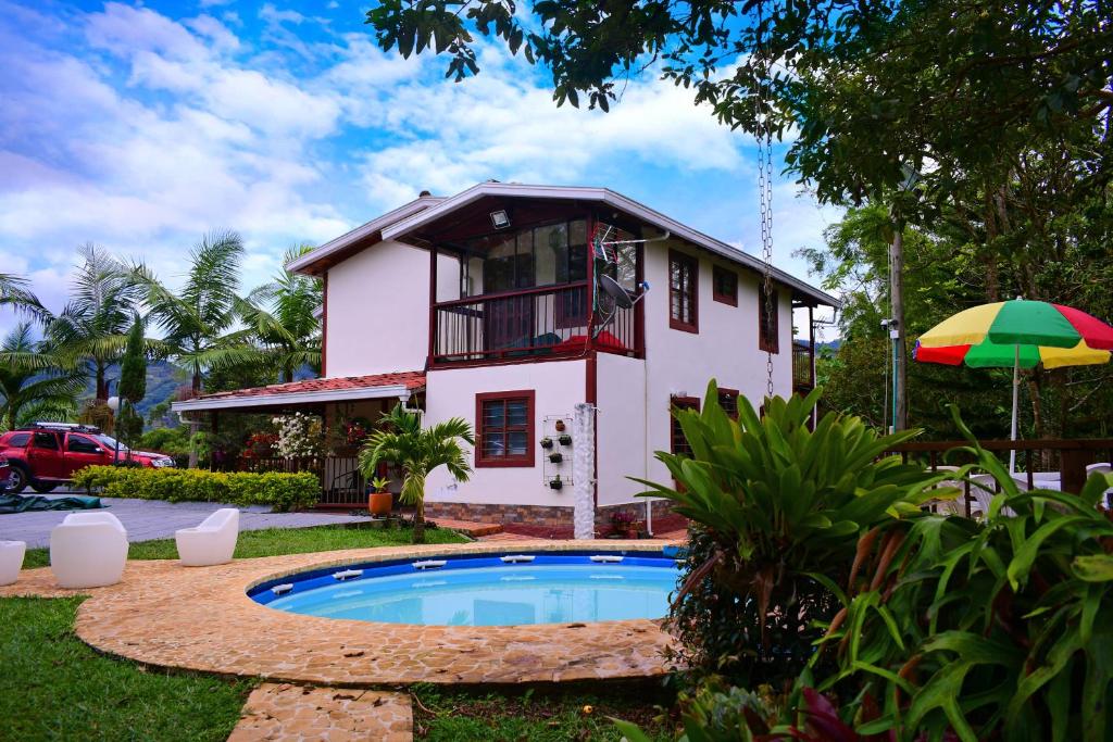 una casa con piscina frente a una casa en Finca en Guatapé a solo minutos de la piedra, con Jacuzzi & piscina en El Peñol