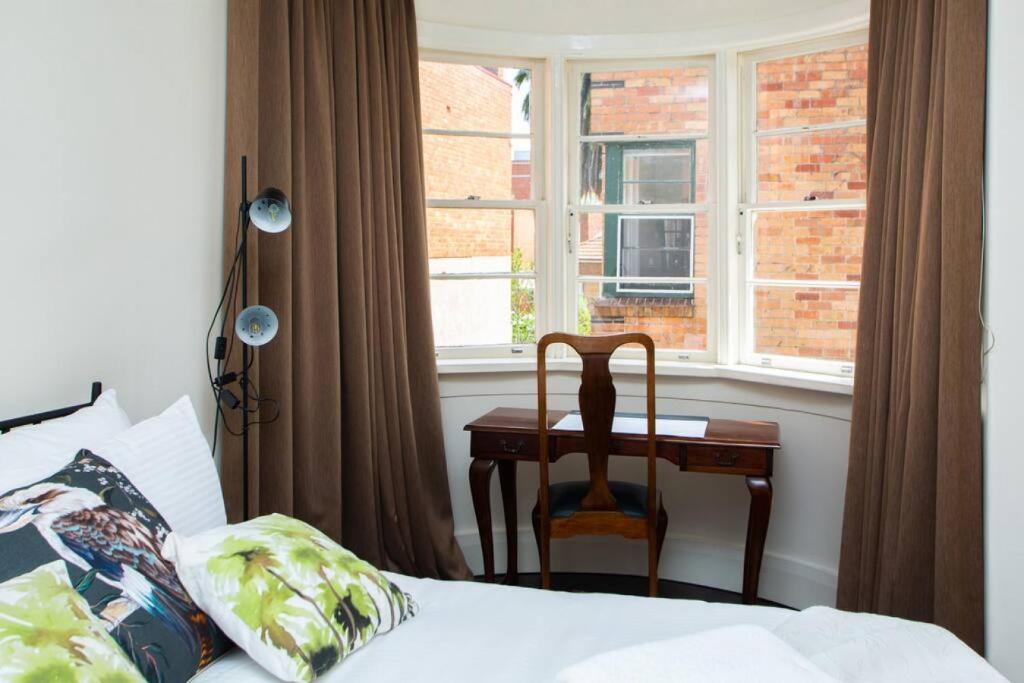 um quarto com uma cama, uma secretária e uma janela em Joli Light Filled Delight Close to the MCG em Melbourne